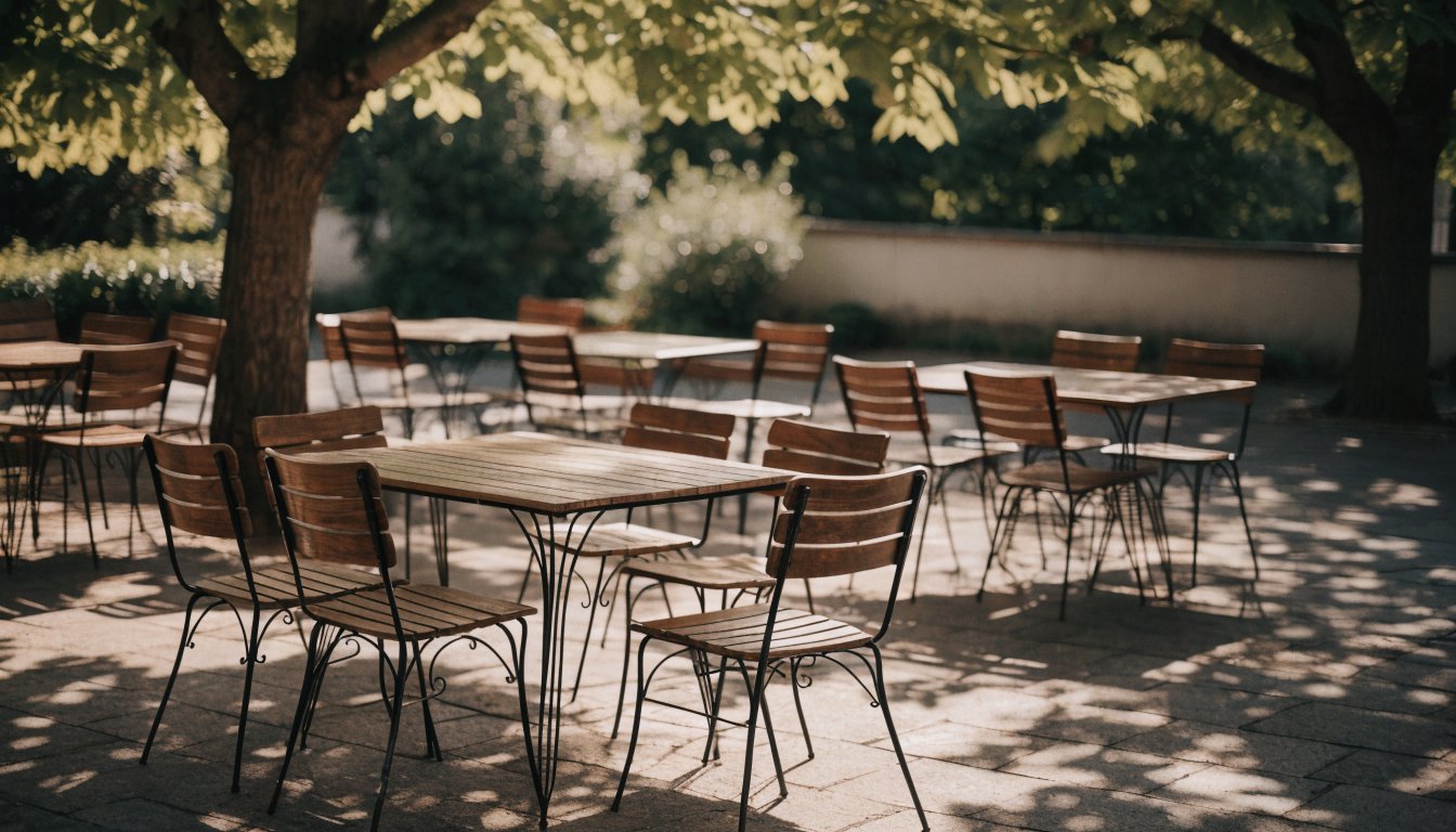 Outdoor cafe terrace with tables under leafy trees (illustrative)