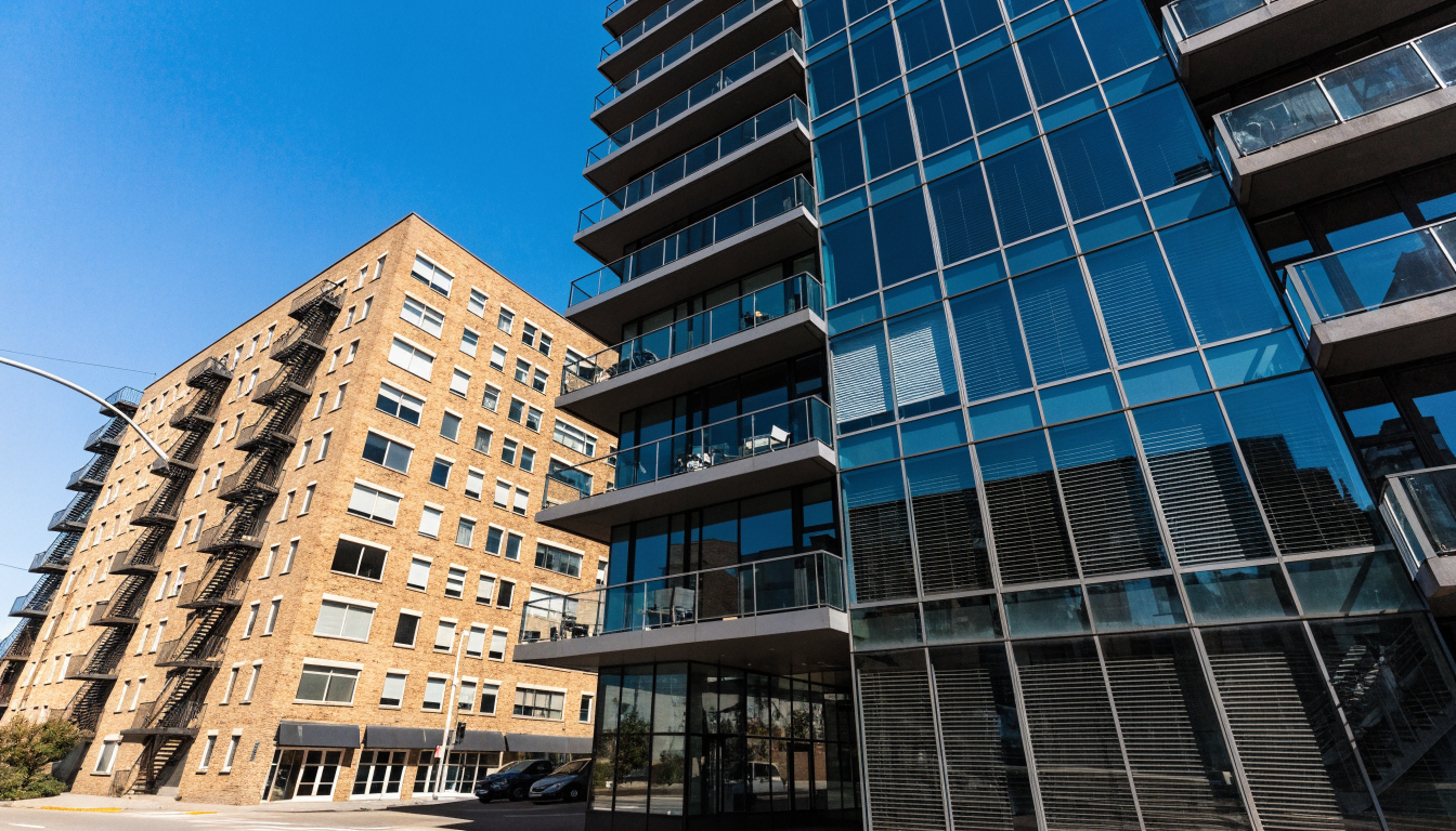 A new glass condominium tower standing directly beside an older 1960s brick walk-up apartment building in Toronto