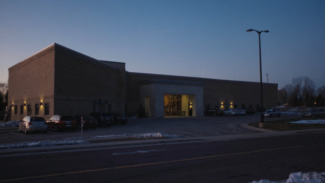 Large single-storey banquet and convention hall with a wide parking lot in a GTA employment area at dusk (illustrative)
