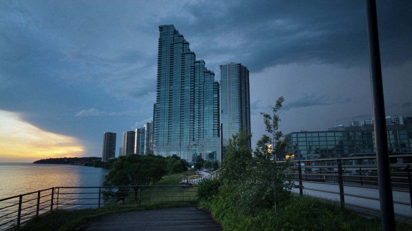 Lakeside promenade with a pier and mid-rise condominiums under a clear sky in Burlington (illustrative)
