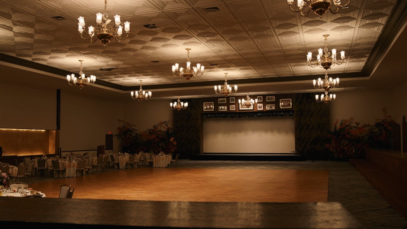 Empty banquet hall set with round tables, chairs and a dance floor under chandeliers in a GTA event venue (illustrative)