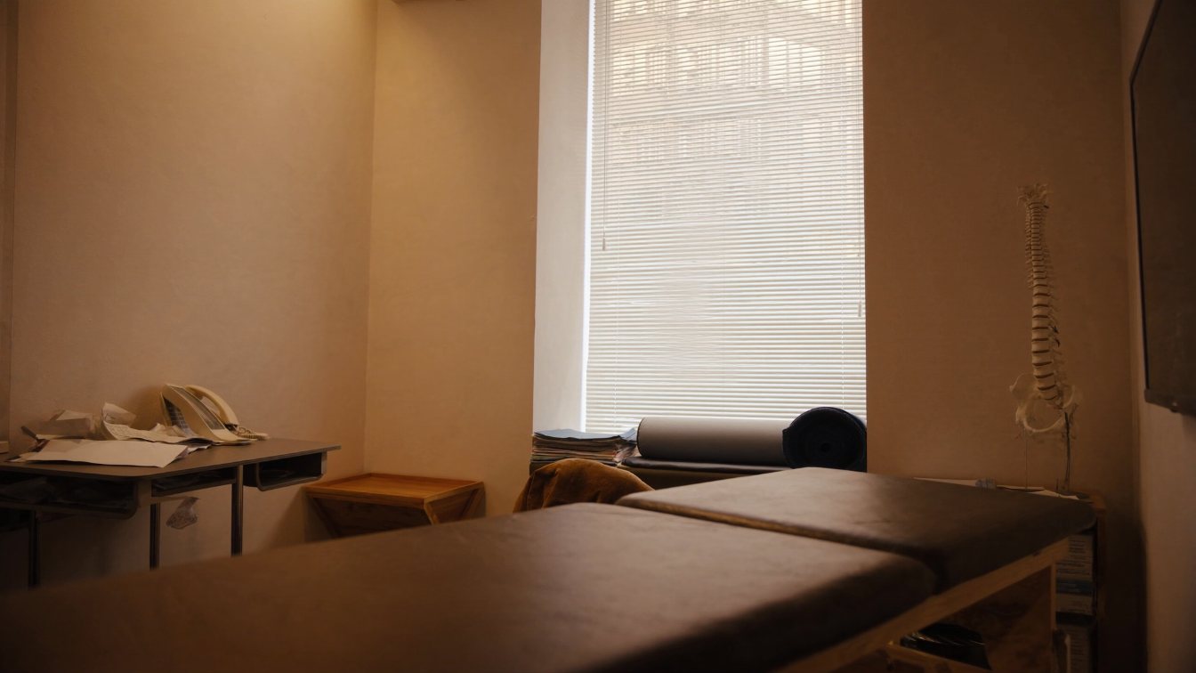 Chiropractic treatment room with an adjusting table and anatomy chart in a GTA clinic (illustrative)