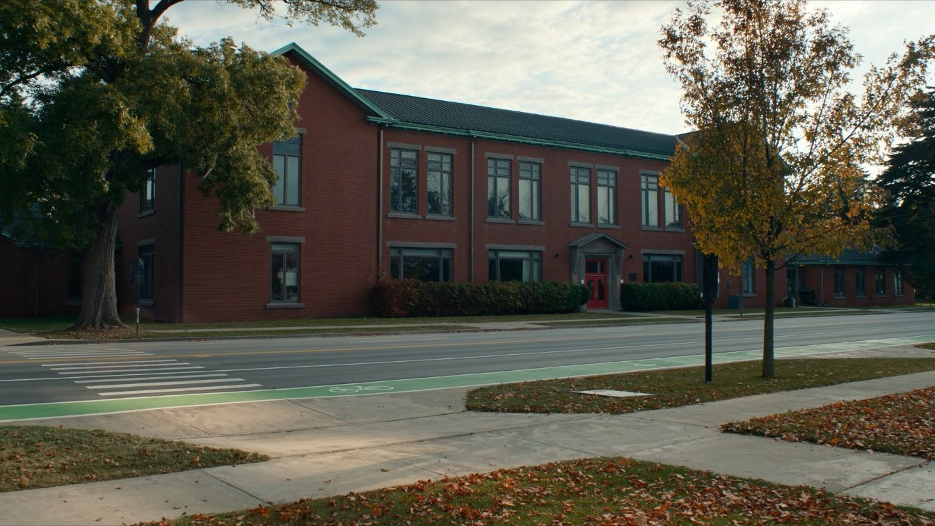 Red-brick independent school building with a front lawn and tall windows in a Toronto neighbourhood (illustrative)