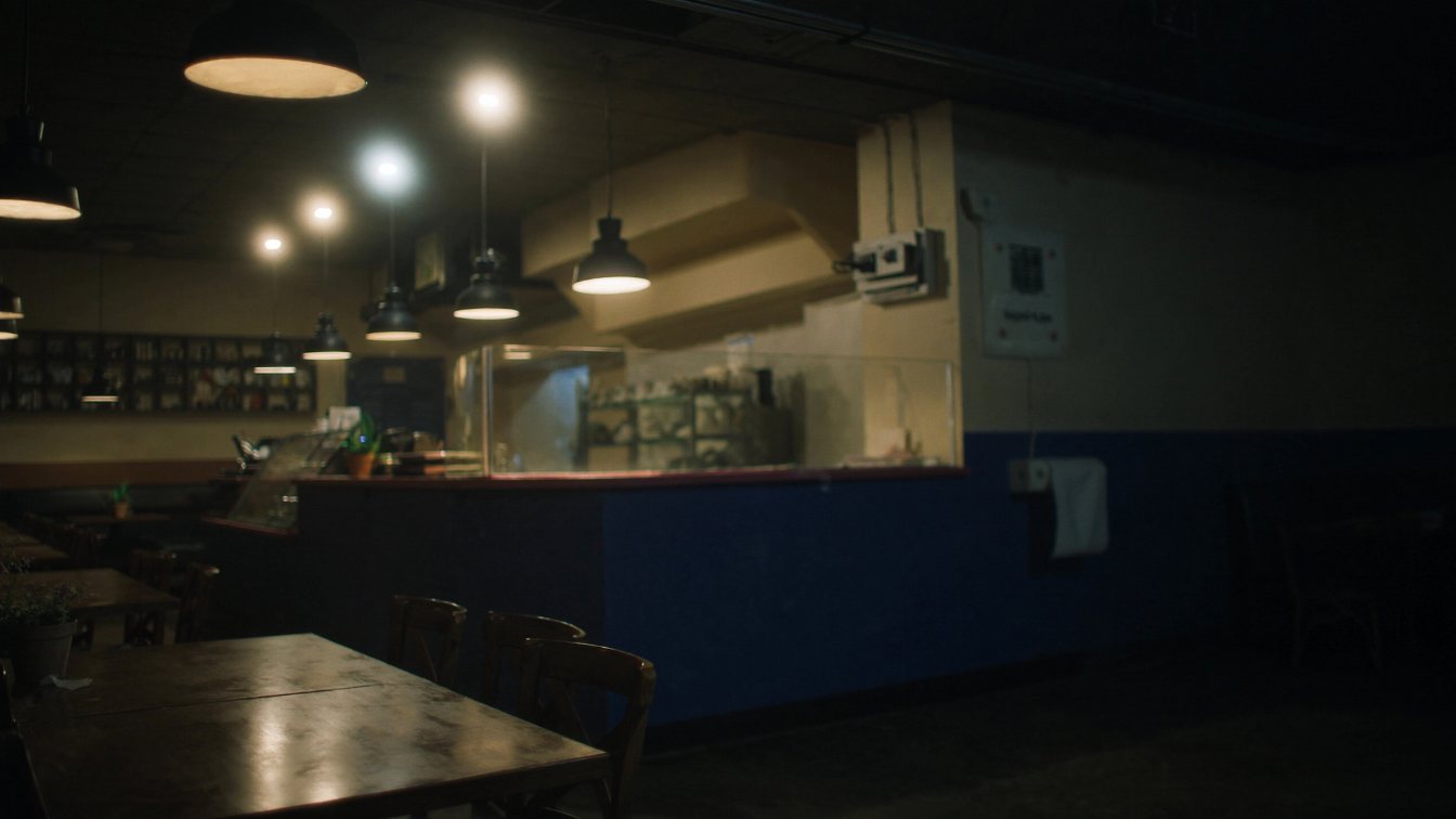 Restaurant dining room with wooden tables and a service counter, lights on after close (illustrative)