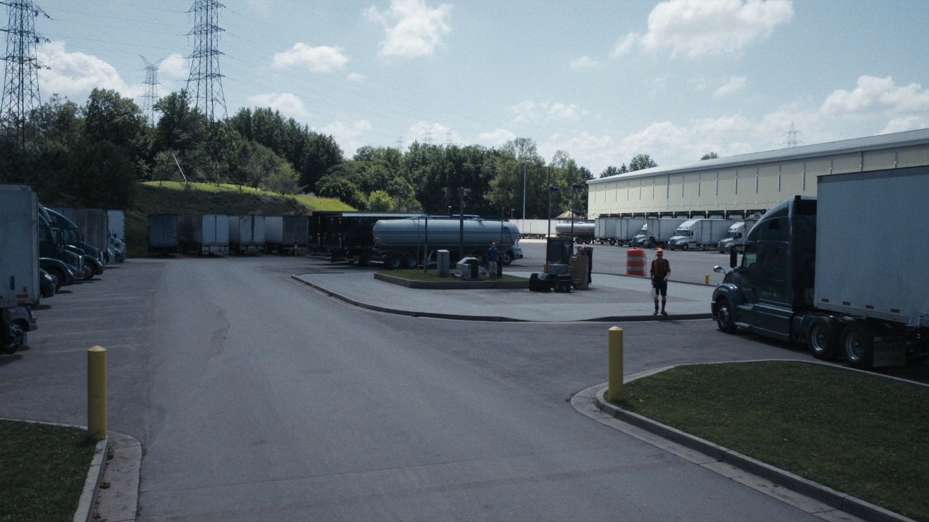 Truck terminal yard with parked tractor-trailers, a fuel island and a cross-dock building in a GTA industrial area (illustrative)