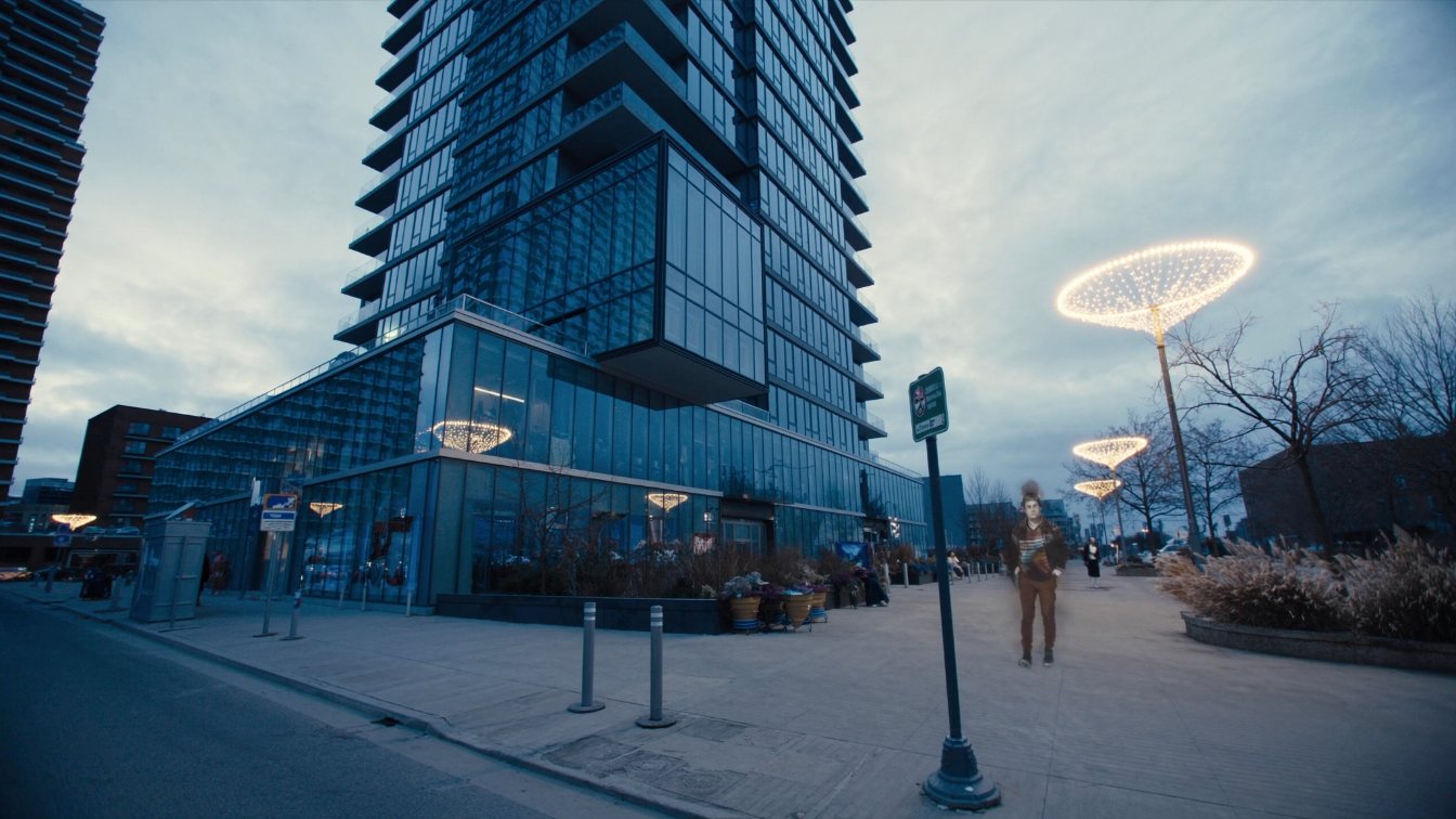 A glass condominium tower with a pale limestone podium and a glass amenity box high on the facade, downtown Toronto (illustrative)