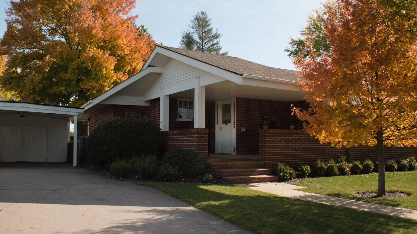 Modest brick bungalow on a tree-lined street in a small Ontario town in autumn (illustrative)
