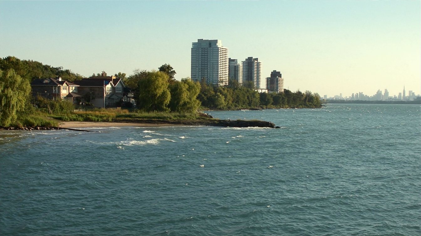 Etobicoke shoreline looking east toward Humber Bay towers with older lakeside houses in the foreground (illustrative)