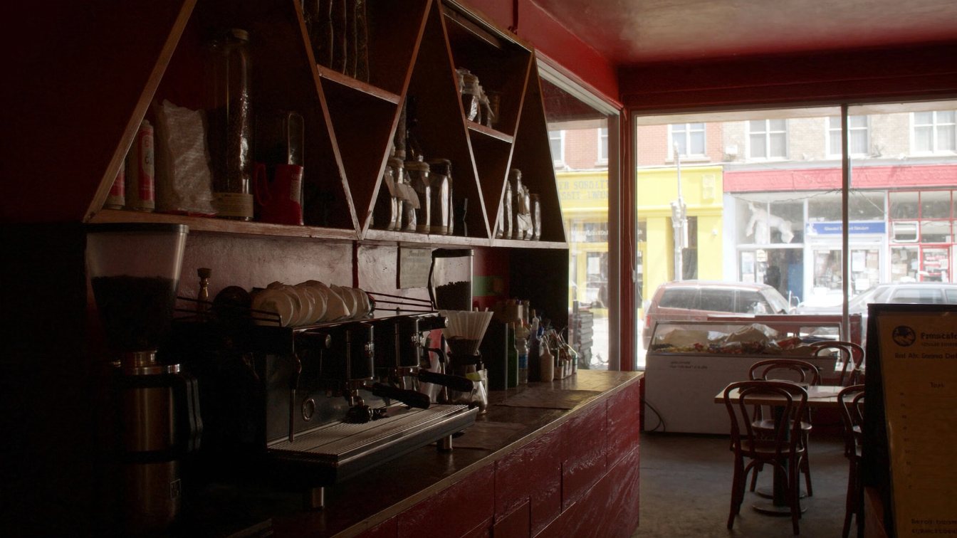 Quiet cafe interior with espresso machine on the counter and chairs set for opening (illustrative)