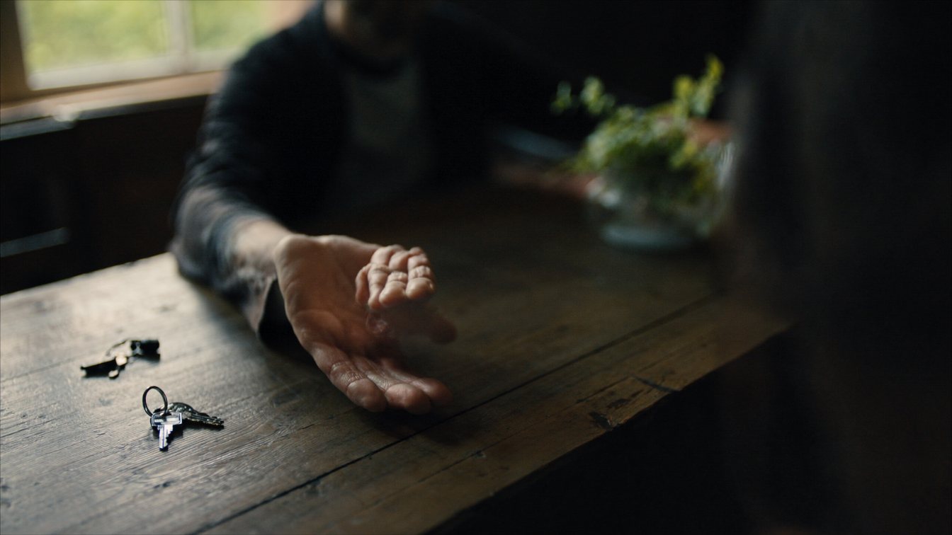 Two generations' hands passing a set of house keys across a table (illustrative)