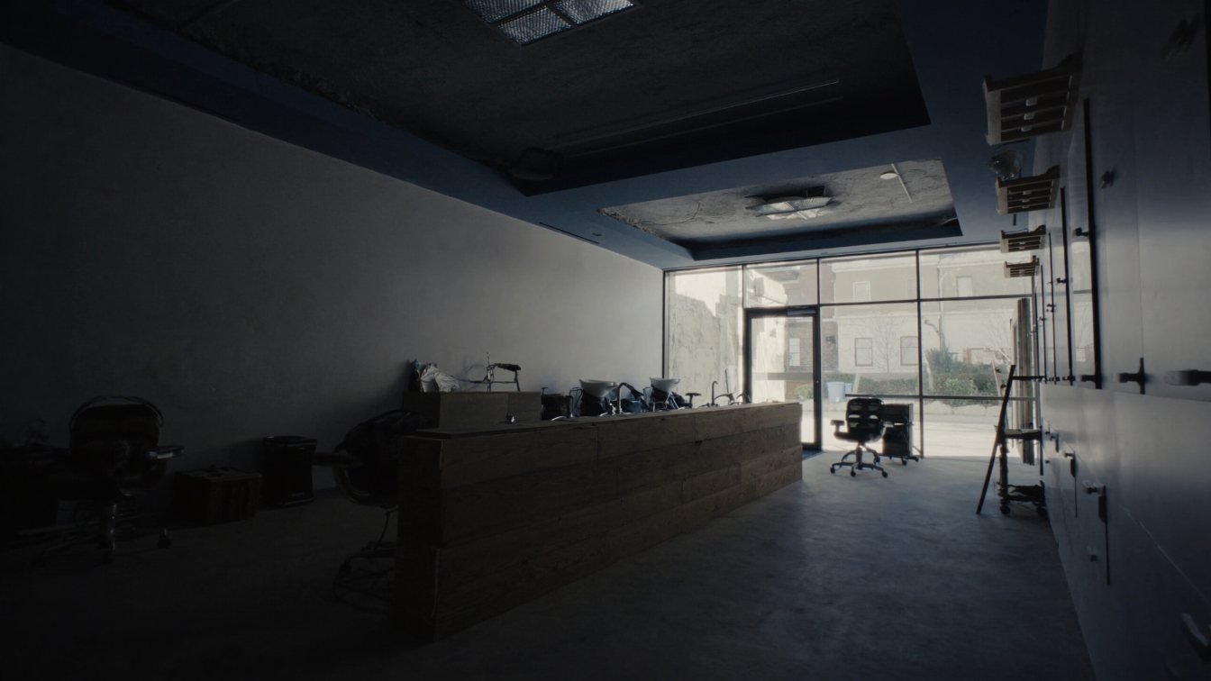 Empty storefront salon space with shampoo basins plumbed along the back wall, ready for fit-out (illustrative)