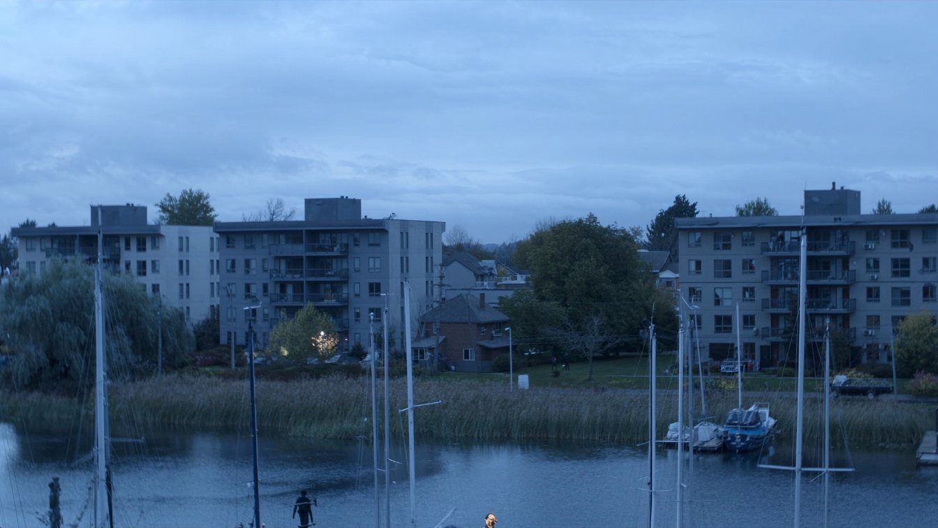 Low-rise and mid-rise condominium buildings near the Oakville lakefront and harbour at dusk