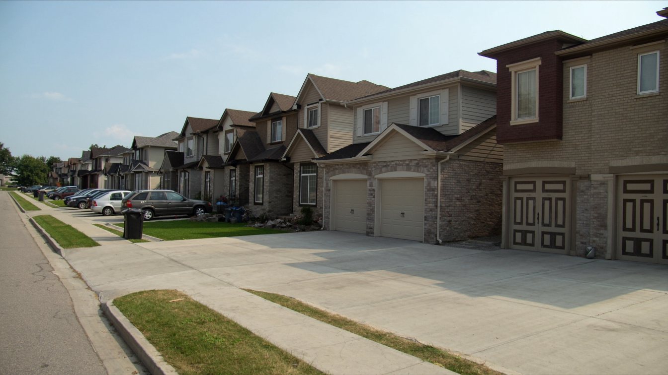 Row of newer two-storey detached and semi-detached houses with garages on a Brampton subdivision street (illustrative)