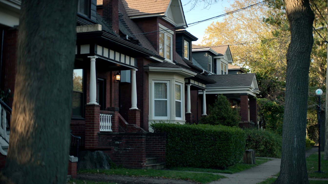 Victorian semi-detached and detached brick houses with porches on a quiet tree-lined street in Toronto's East End (illustrative)