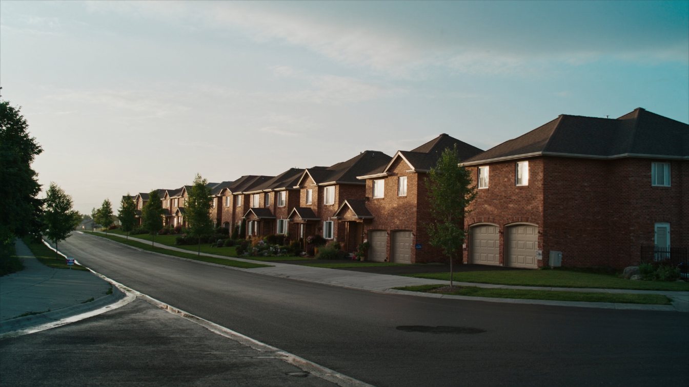 Two-storey brick detached houses with double garages on a curved Mississauga residential street (illustrative)