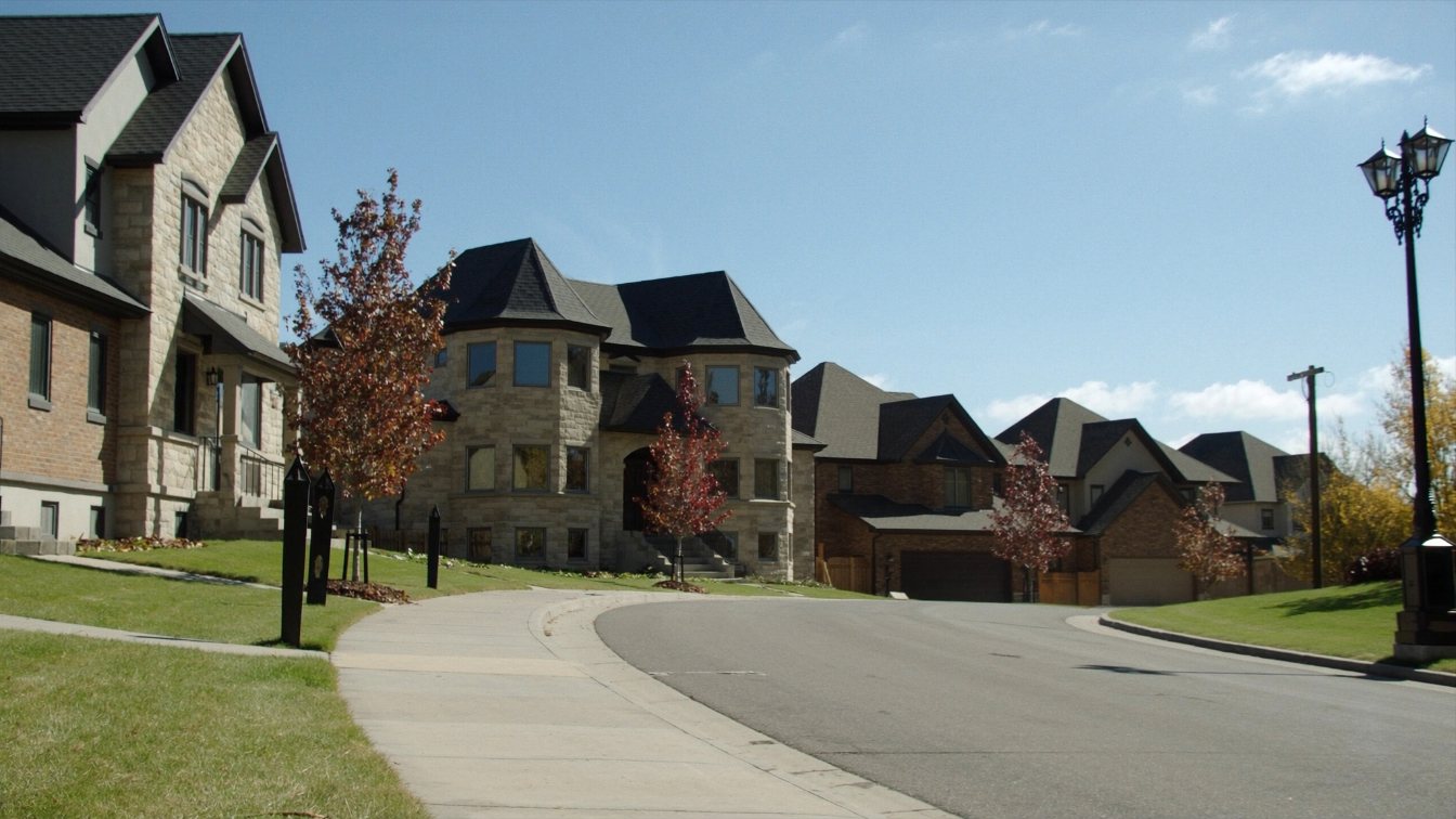 Large detached homes on a curving street in Vaughan, York Region, in early autumn (illustrative)