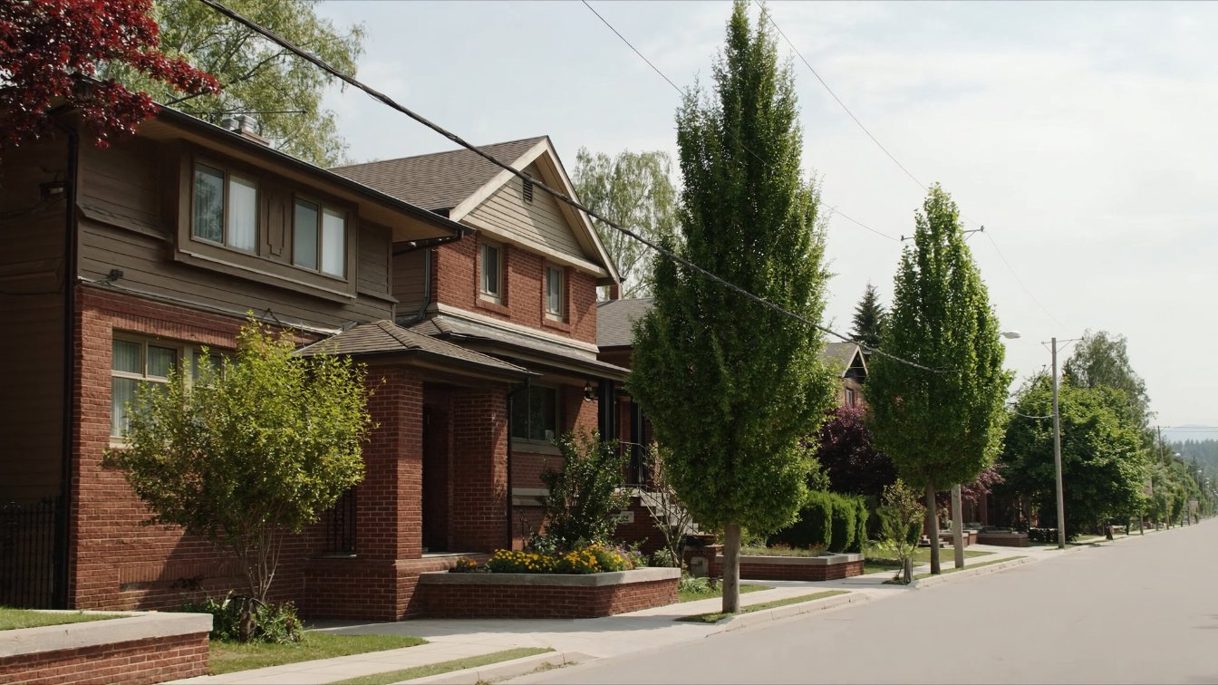 Row of older brick semi-detached and detached houses with front porches on a tree-lined street in Toronto's West End (illustrative)