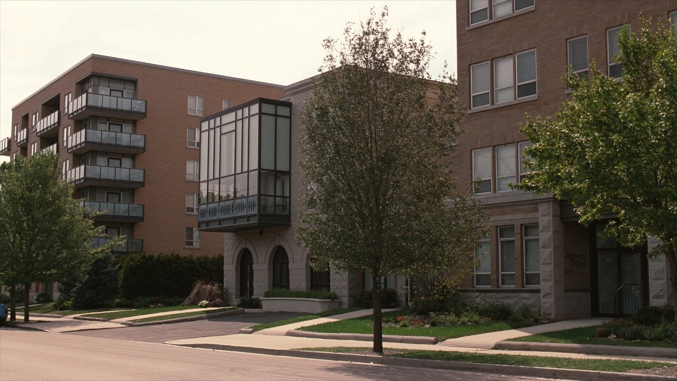 Two neighbouring condominium buildings of similar age side by side on a Toronto street (illustrative)