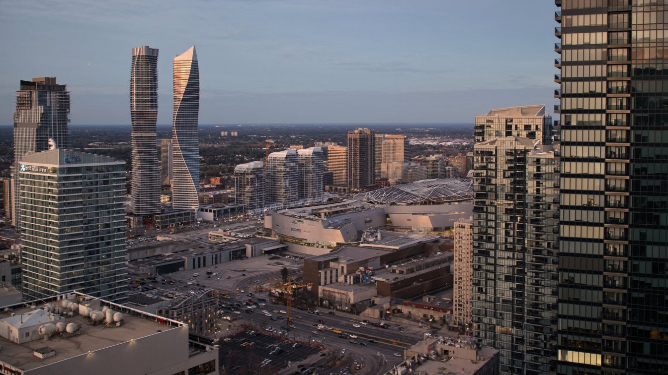 Cluster of tall glass condominium towers around a large shopping centre in downtown Mississauga at dusk (illustrative)