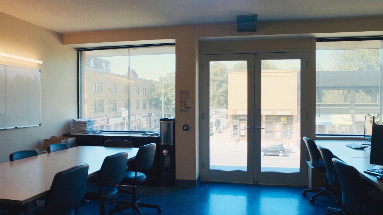 Second-floor office suite above street-level shops on a GTA main street, large windows and a quiet corridor (illustrative)