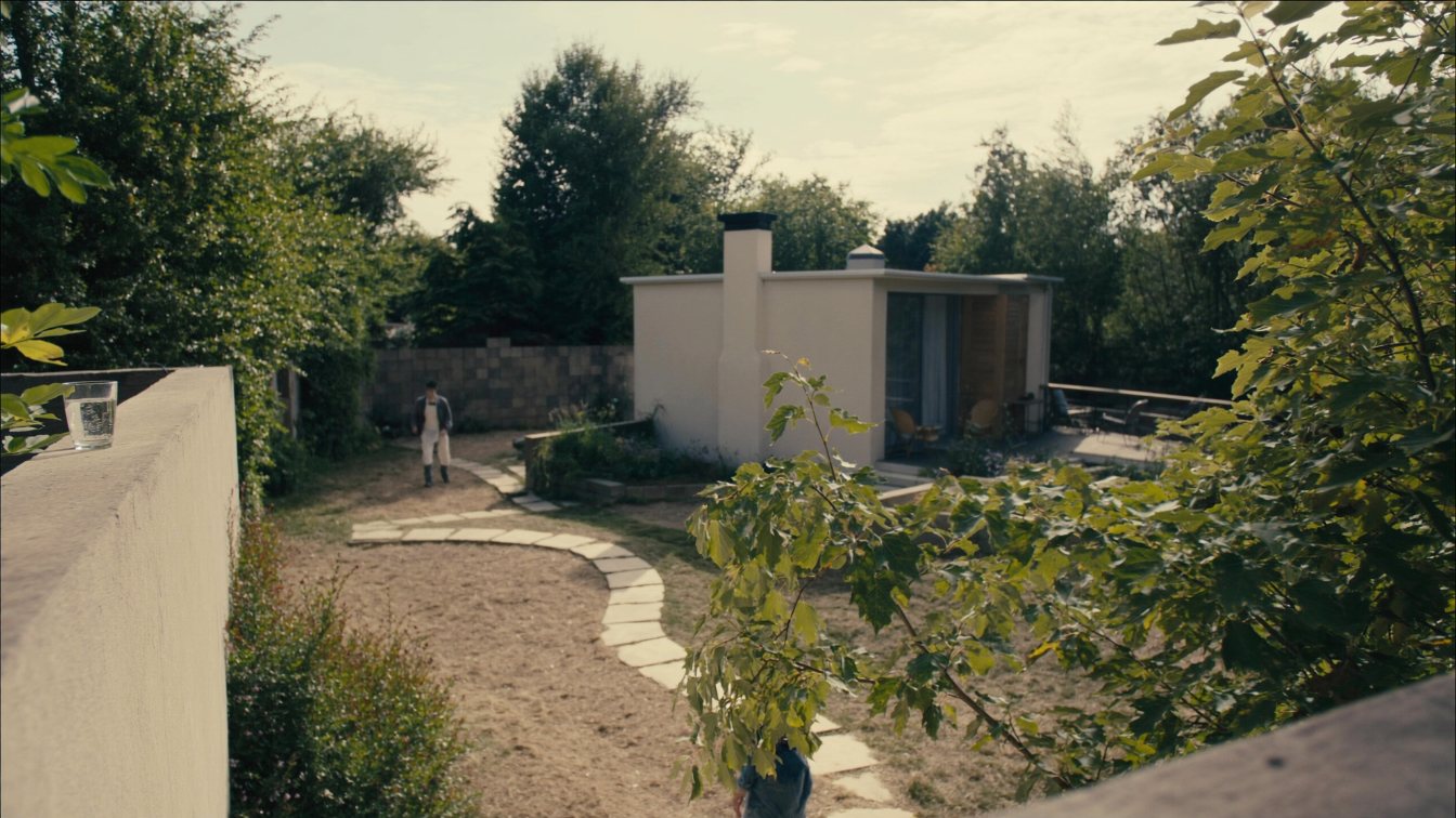 Small modern garden suite in the backyard of a Toronto house with a stone path from the main home (illustrative)