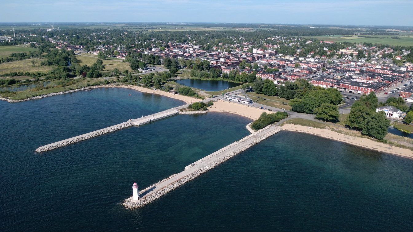 Twin harbour piers with a lighthouse and a lakeside park beside an old canal village in Port Dalhousie (illustrative)