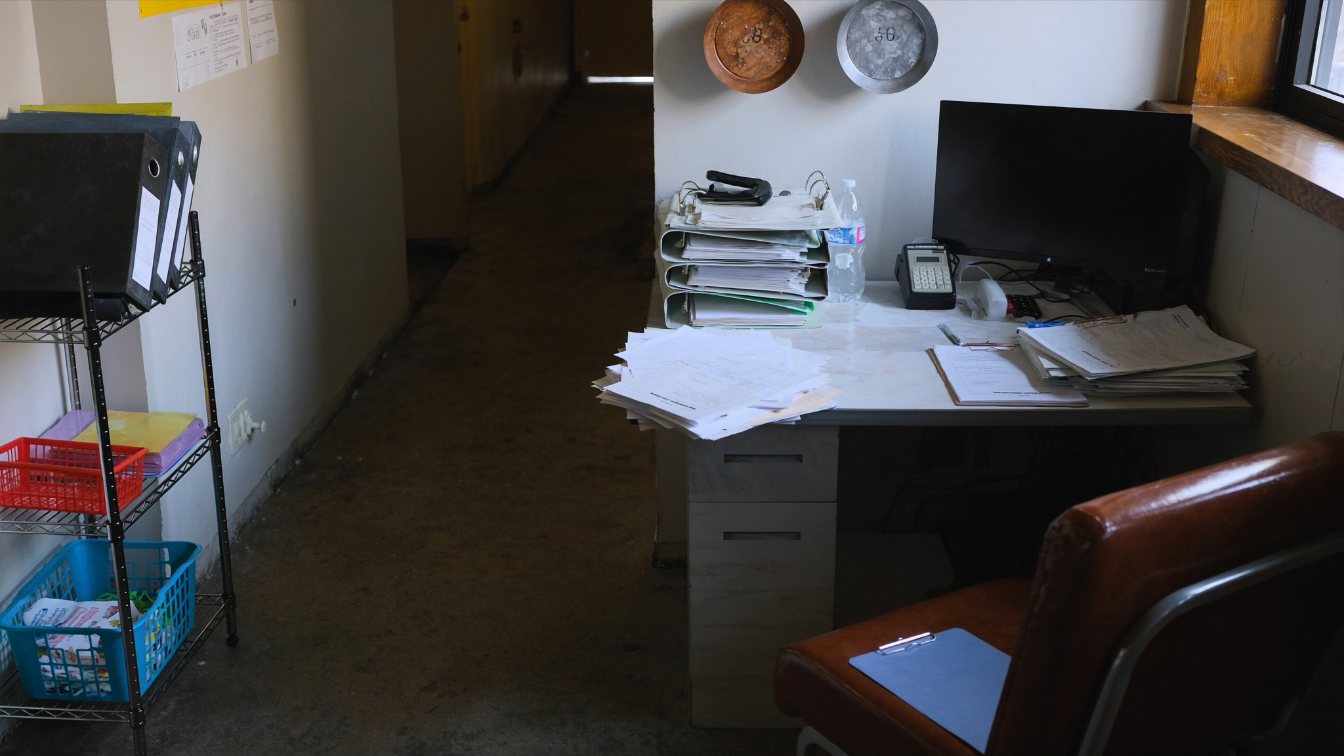 Restaurant back office desk with binders, invoices and a point-of-sale terminal (illustrative)