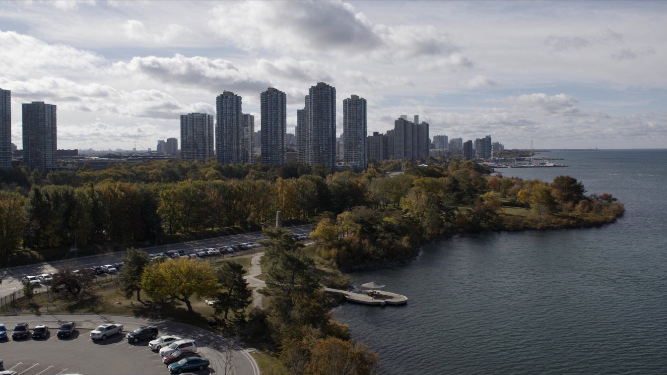 Aerial view of the Lake Ontario shoreline with parkland, low-rise homes and condo towers in the Greater Toronto Area (illustrative)