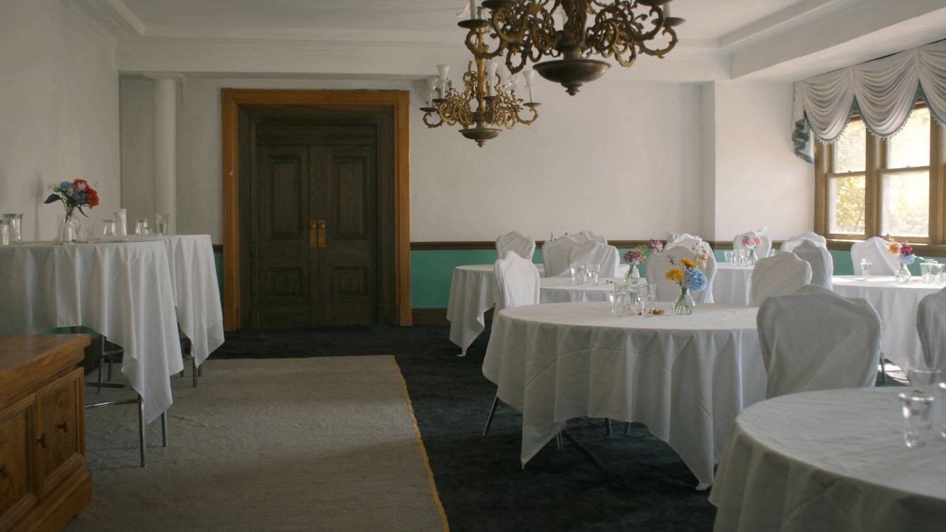 Seniors residence dining room with set tables and afternoon light (illustrative)