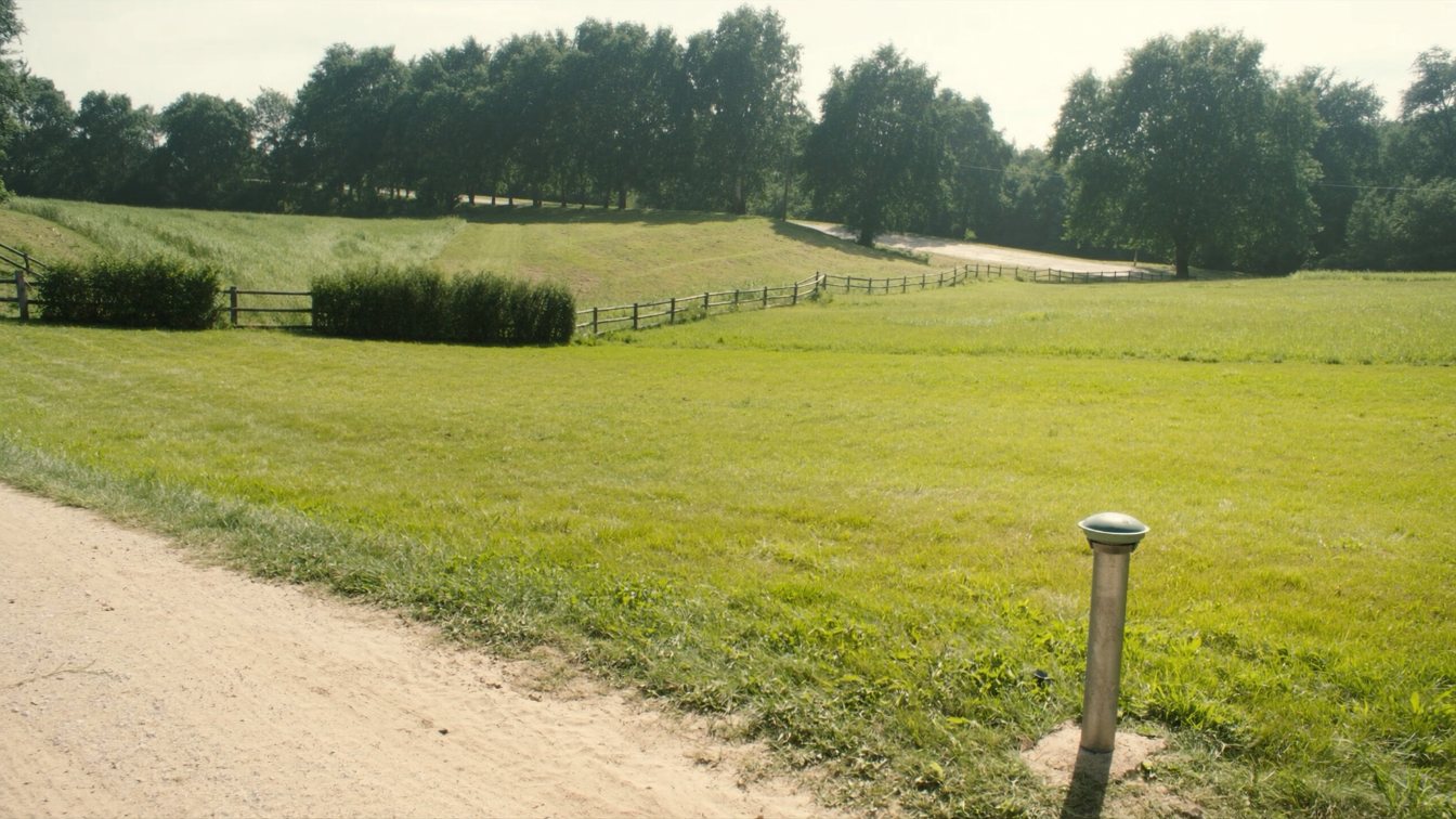 A rural building lot with a well casing and a grassed septic bed area near a country road in Ontario (illustrative)