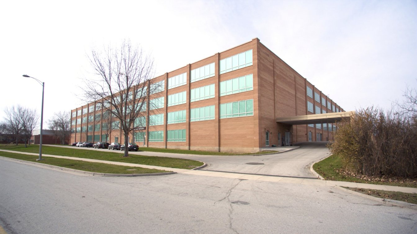 Multi-storey climate-controlled self-storage building converted from an older industrial building beside an arterial road (illustrative)