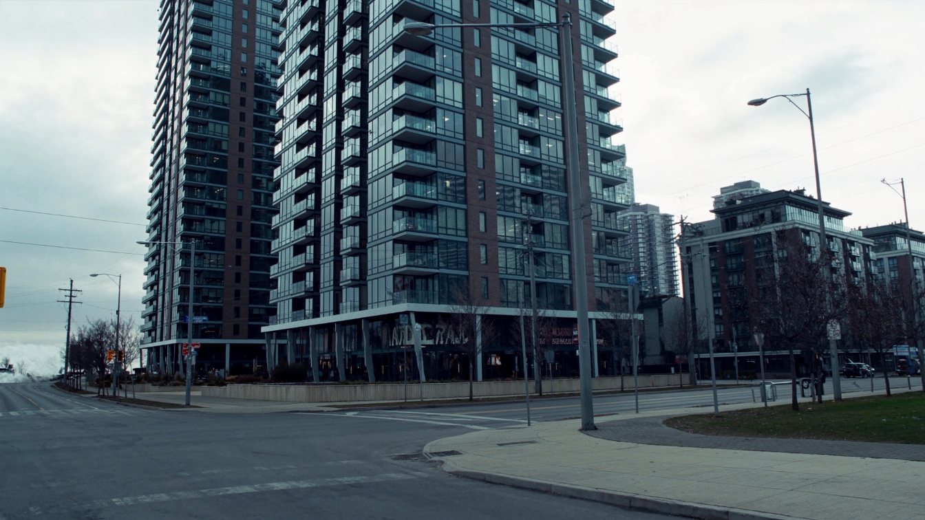 Two modern glass condominium towers of different heights on Yonge Street in downtown Toronto (illustrative)
