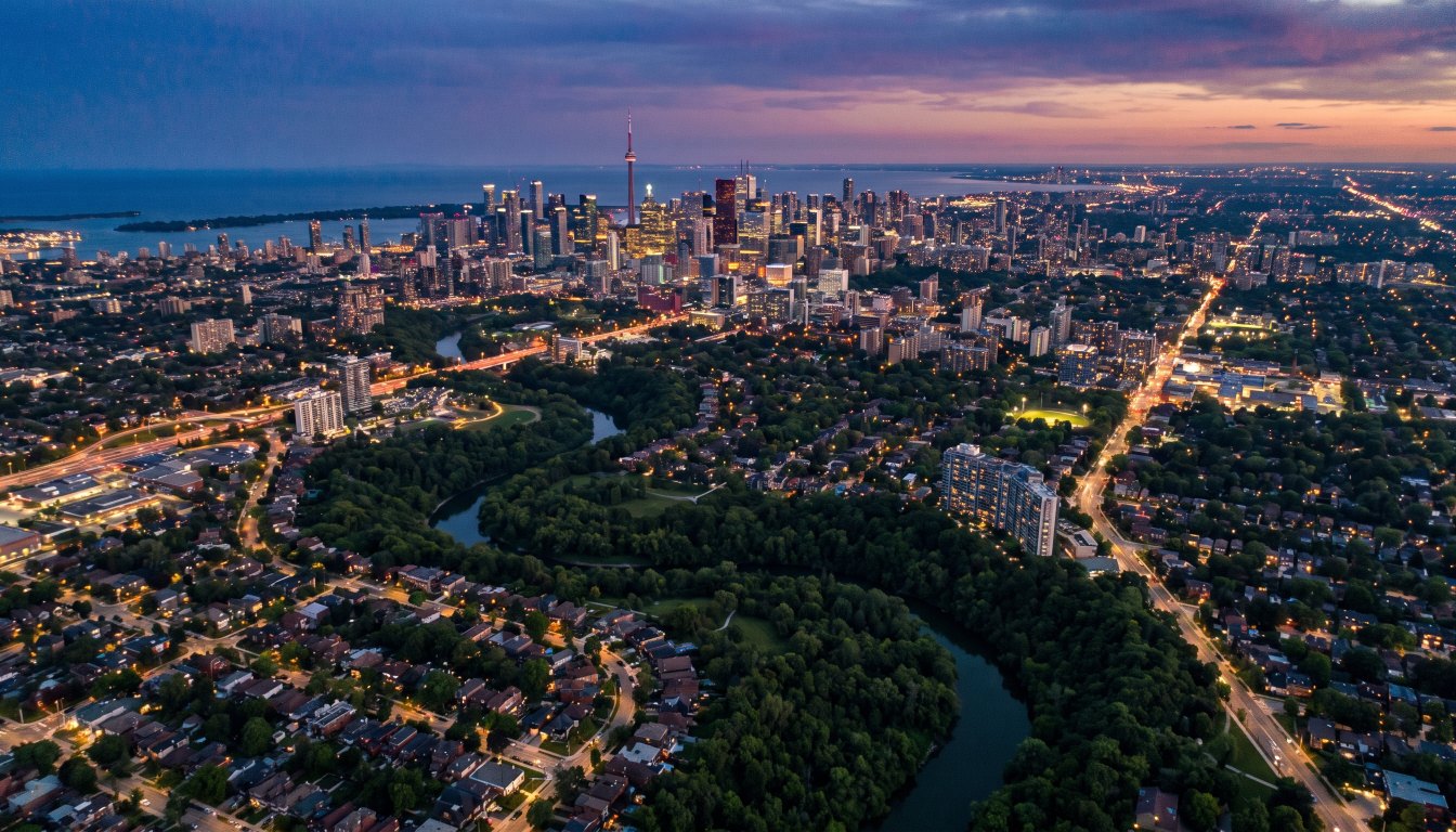 Aerial view at dusk of west and north Toronto with the downtown skyline between them