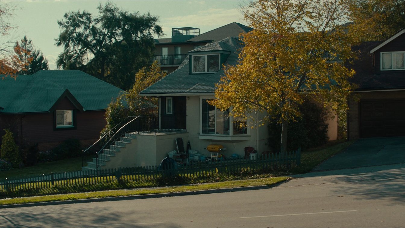 Row of GTA homes beside a low-rise condo building on a quiet autumn street (illustrative)