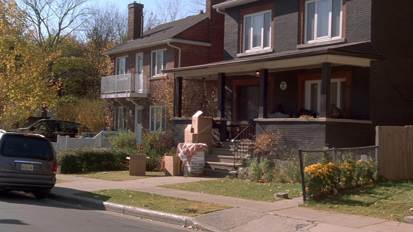 Two Toronto houses, one with moving boxes on the porch (illustrative)