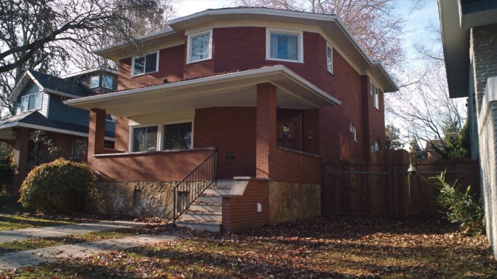 A semi-detached brick home with a front porch on a tree-lined Toronto street in autumn (illustrative)