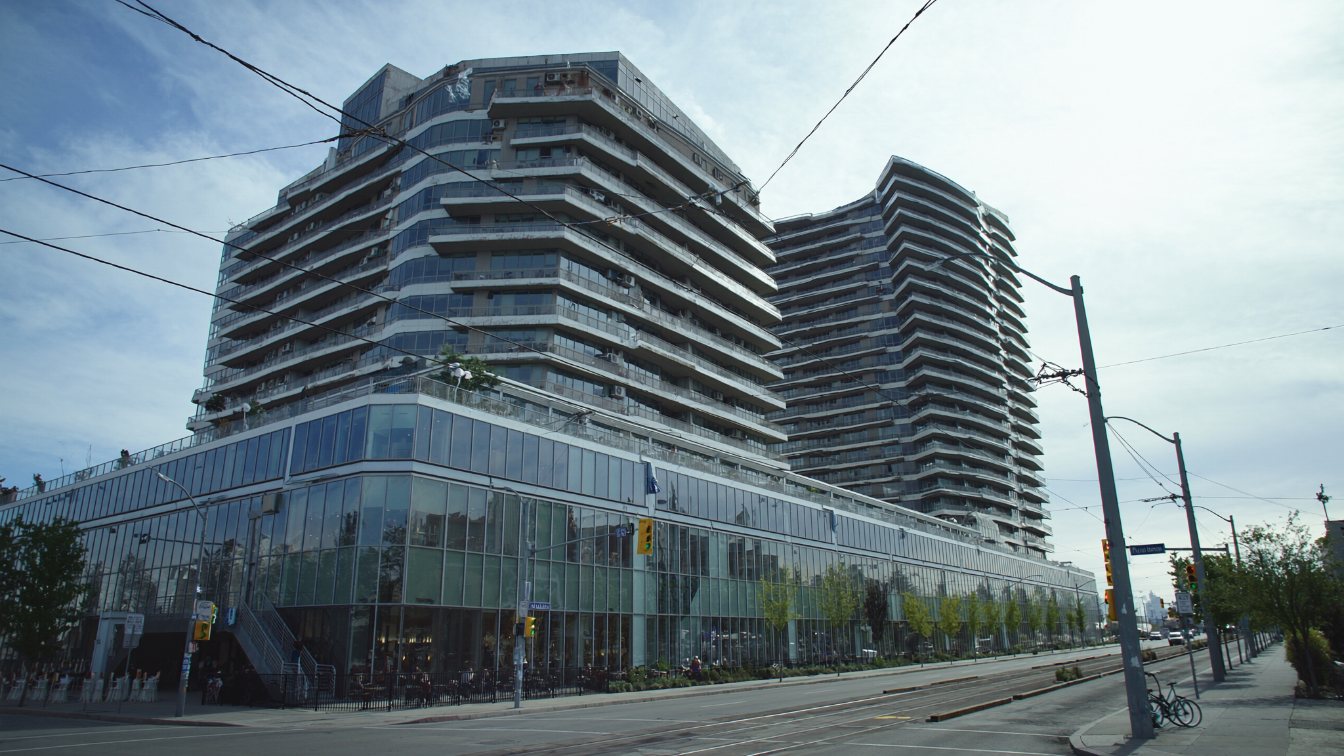 Two mid-rise glass and concrete condominium towers above a retail podium on King Street West in Toronto (illustrative)