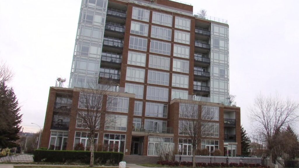 A row of brick freehold townhouses beside a mid-rise condominium building on a quiet GTA street (illustrative)