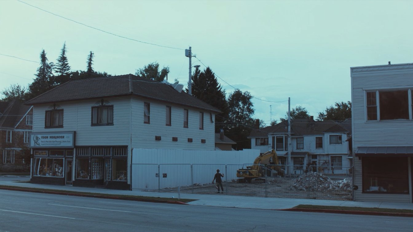Fenced, idle construction lot on a Mimico main street (illustrative)