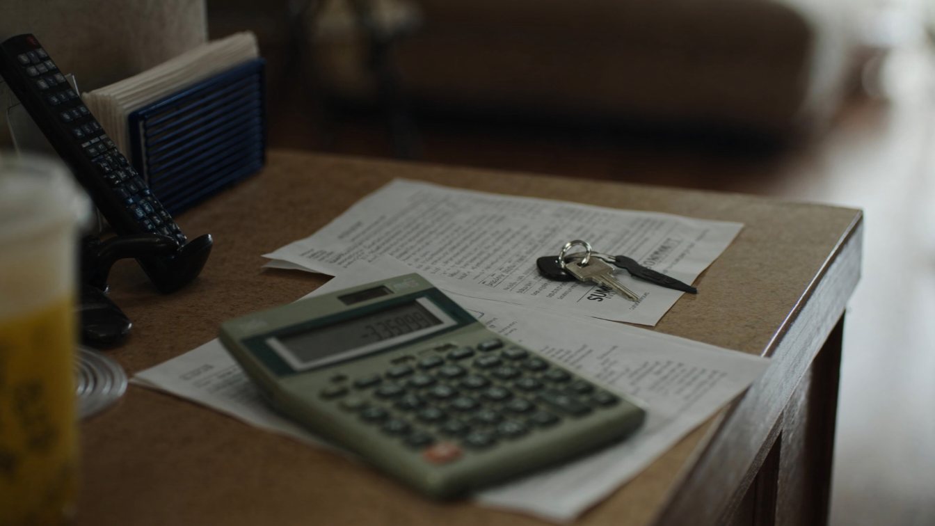 Mortgage statement, calculator and keys on a table (illustrative)
