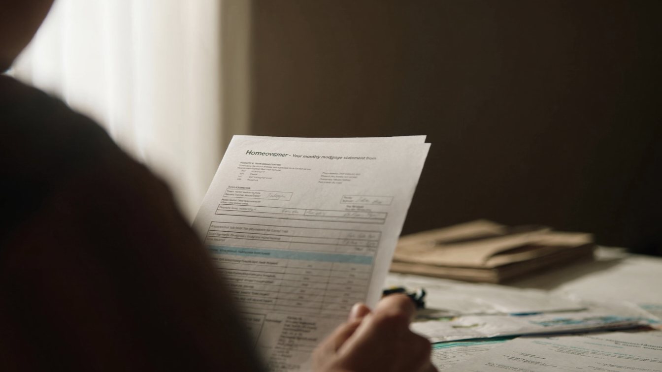 Homeowner with a mortgage statement and bills (illustrative)