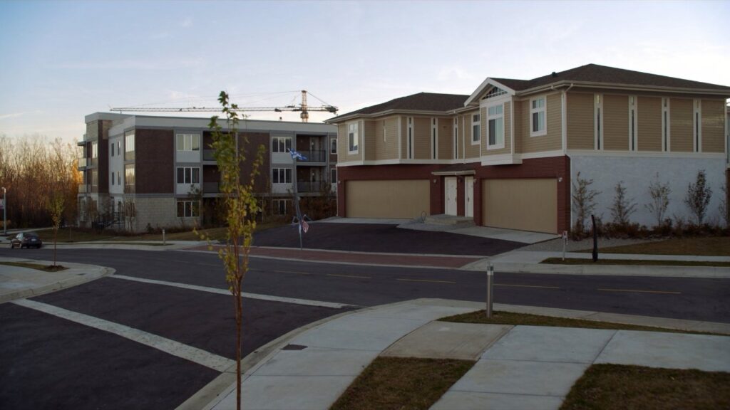 Newer freehold townhouses and a low-rise condominium on a suburban street east of Toronto (illustrative)