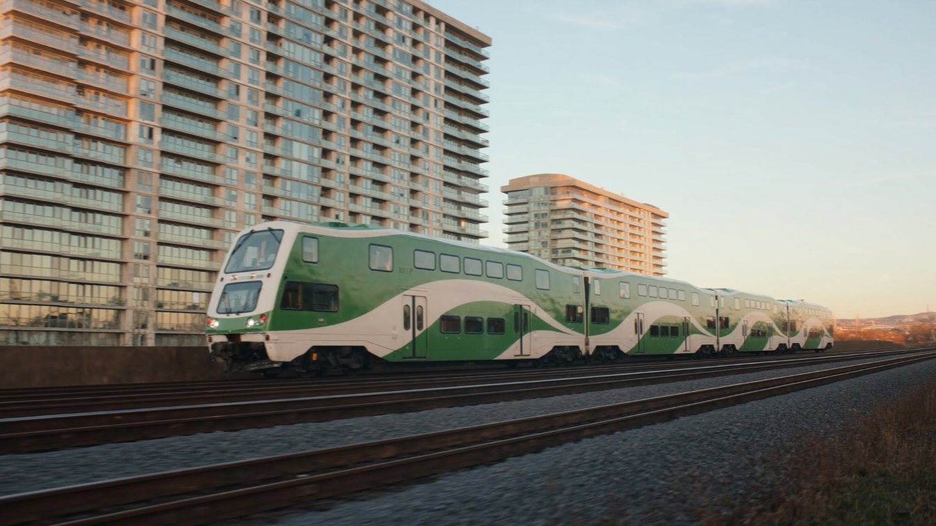 Commuter train passing waterfront condo towers (illustrative)