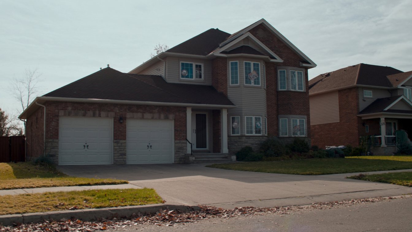 Vacant suburban house with an overgrown lawn (illustrative)