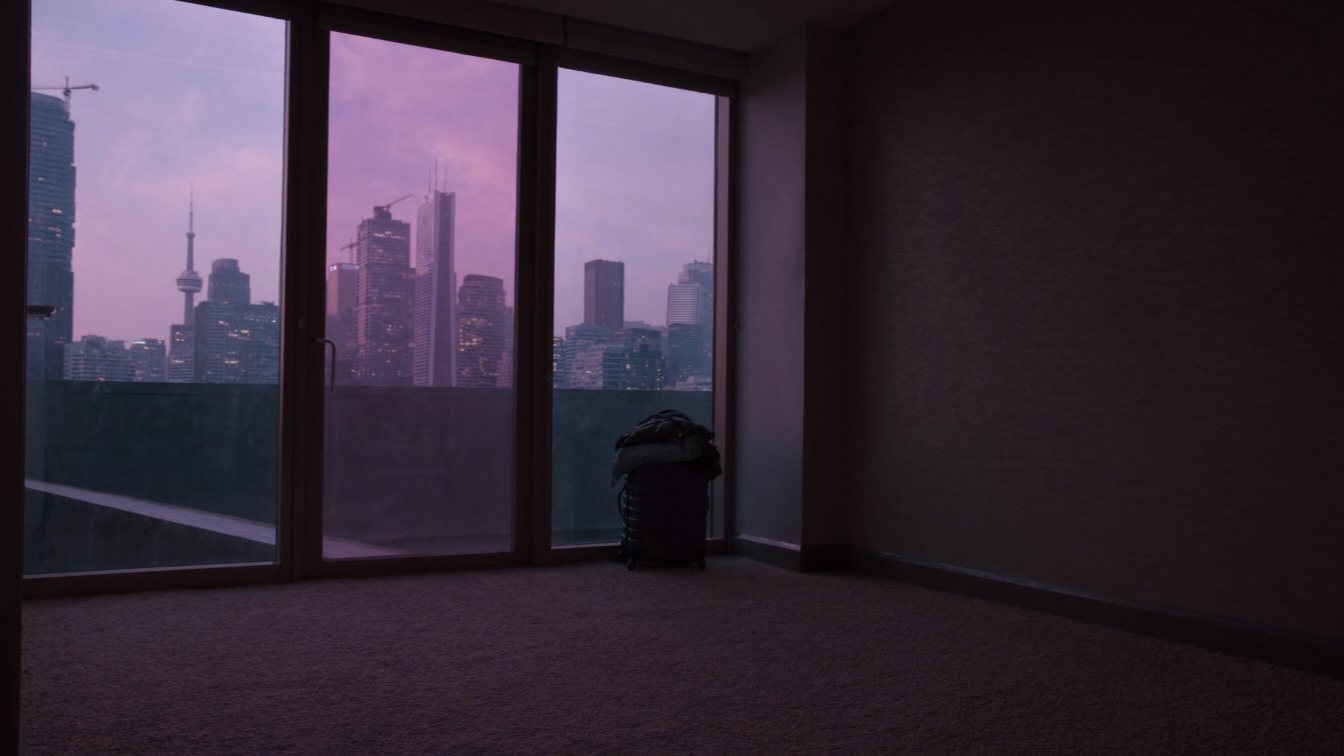 Condo tower with a suitcase in the foreground (illustrative)