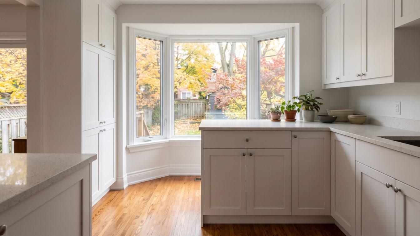 Renovated kitchen with white cabinets and refinished oak floors in an older Toronto house (illustrative)