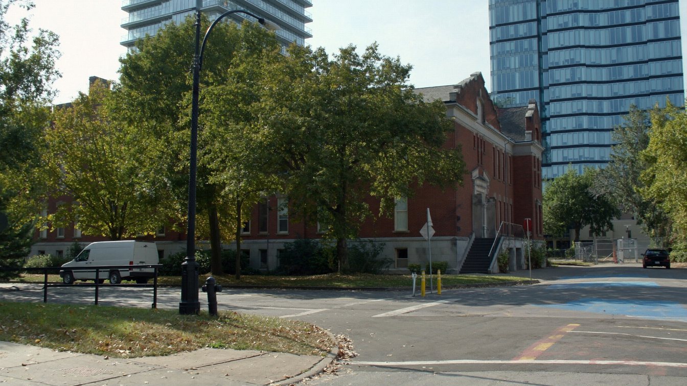 Historic brick public school beside new midtown Toronto condominium towers near Yonge and Eglinton (illustrative)